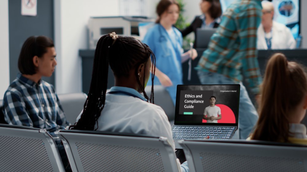 African american physician working with greenscreen on laptop computer, sitting in hospital reception lobby. Medic using isolated chroma key background with blank copyspace and mockup template.