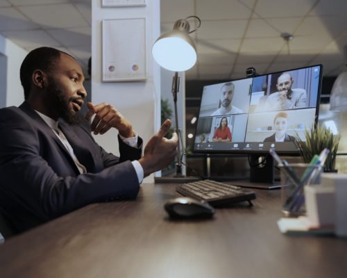 Entrepreneur explaining investment graph to remote team during online videocall meeting conferece. Business colleagues working late at night at marketing strategy in company statup office